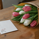 Quel poème pour maman anniversaire choisir pour lui dire qu'on l'aime ? Carte manuscrite posee pres d'un bouquet de tulipes
