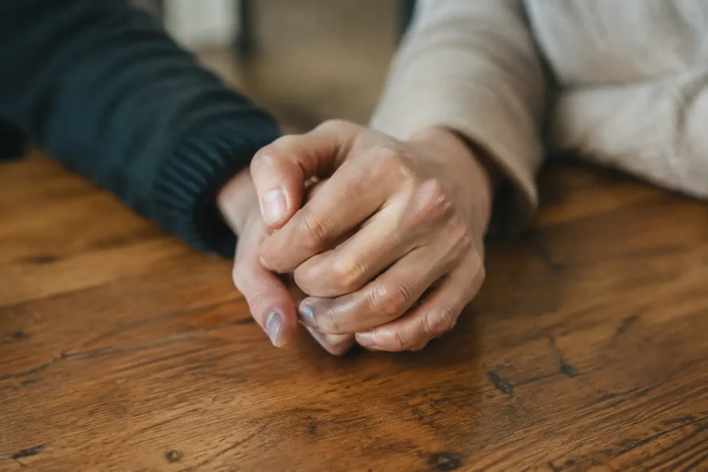 Deux mains serrees ensemble sur une table en bois