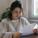Des poèmes et messages d'anniversaire pour souhaiter un joyeux anniversaire à sa maman Femme assise tenant feuille blanche lettres manuscrites